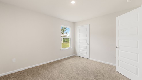 Bedroom with carpet floors and closet and window.