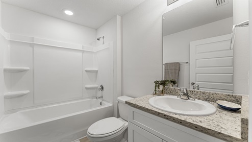 Bathroom with single-vanity granite countertops and tub and shower and toilet.
