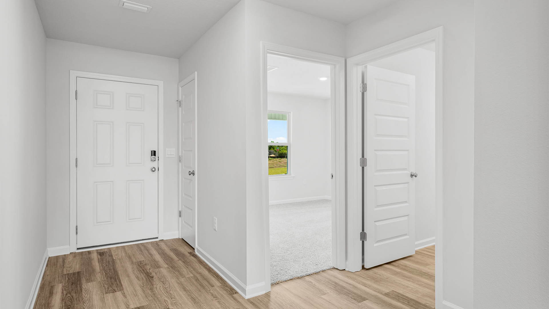Front entrance by front door and bathroom and 2 bedrooms with EVP flooring.