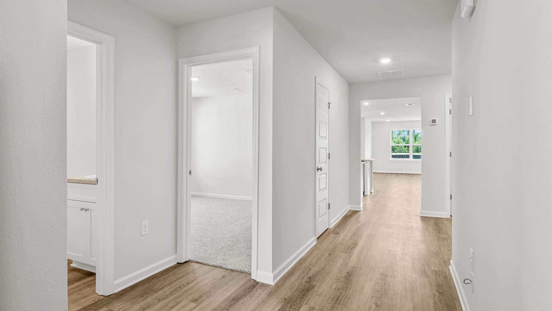 Front hallway by front door and bathroom and 2 bedrooms with EVP flooring.