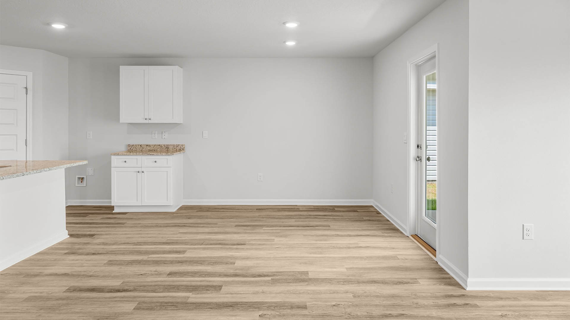 Dining area with EVP flooring and back door next to kitchen.