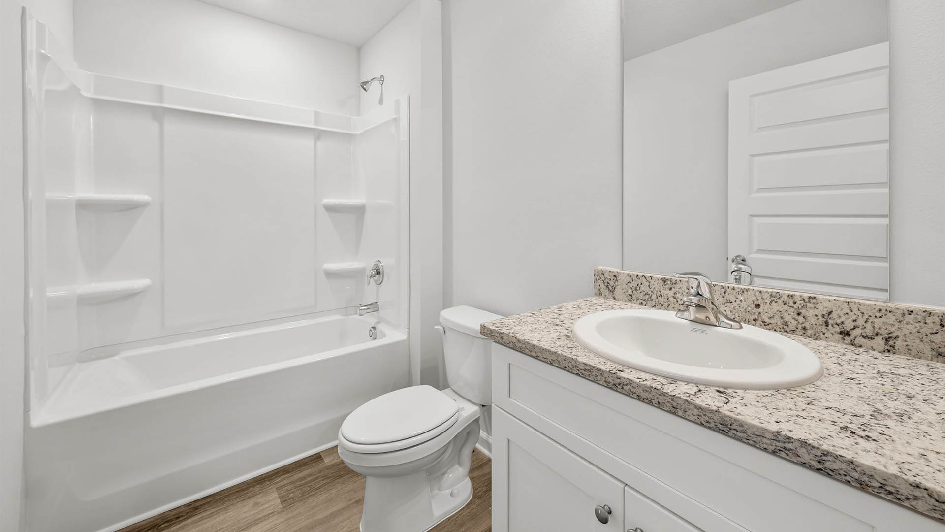 Bathroom with EVP flooring and single vanity granite countertops and toilet and tub and shower.