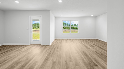Open living room and dining area with EVP flooring and two windows and backdoor.