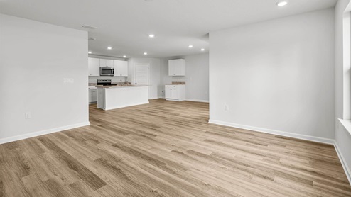 Open living room with EVP flooring looking into kitchen.