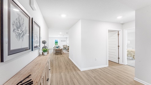 Hallway by garage entrance and laundry room and bedroom.