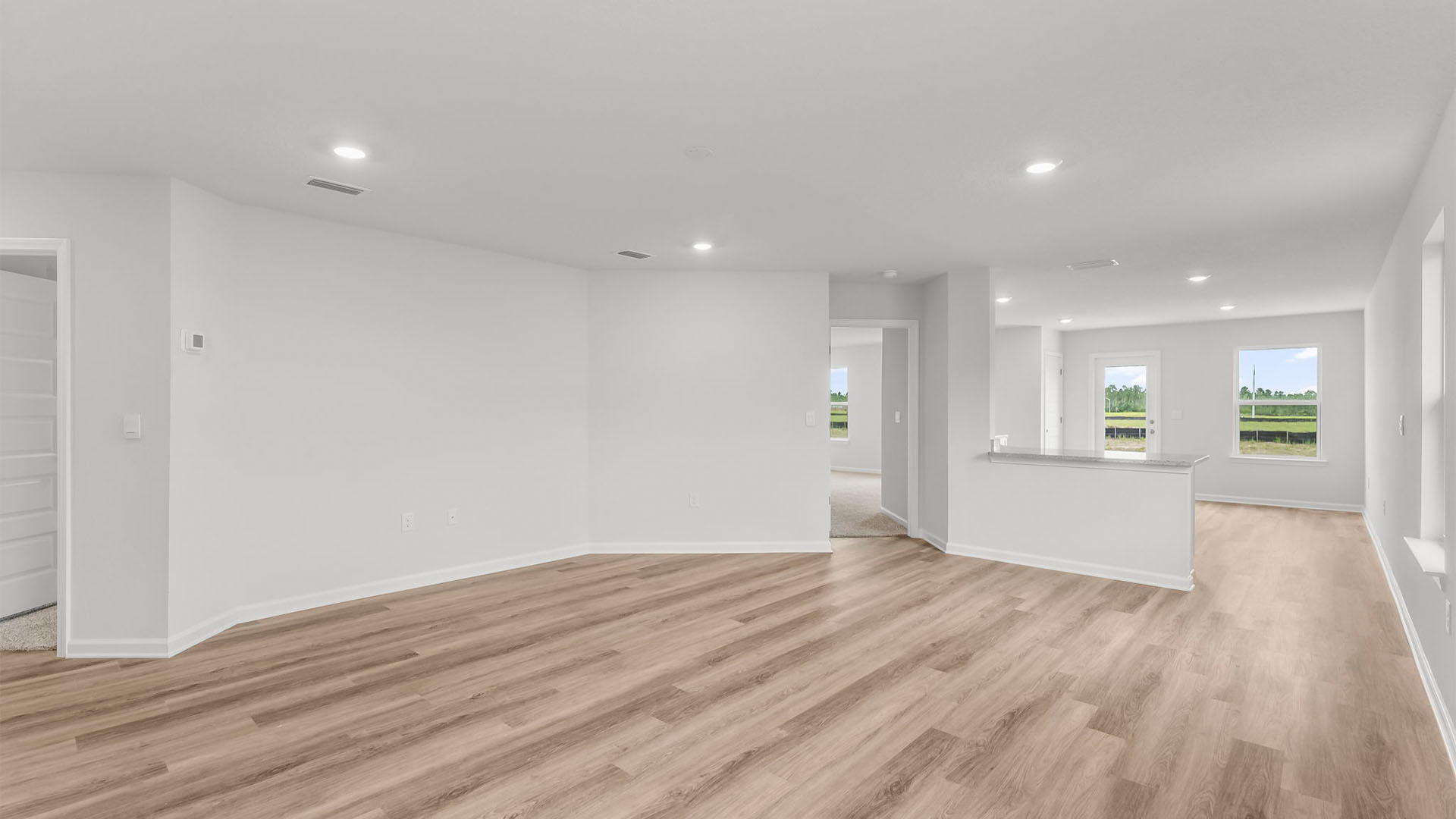 Living room with EVP flooring and open kitchen.