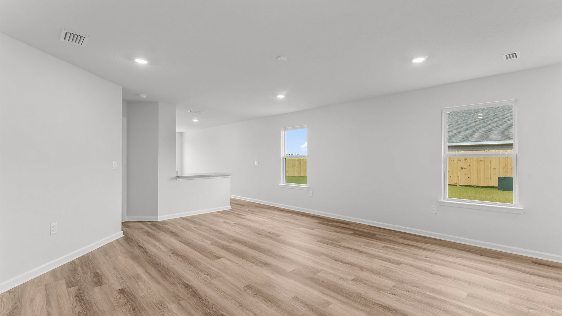 Living room with EVP flooring and two windows.