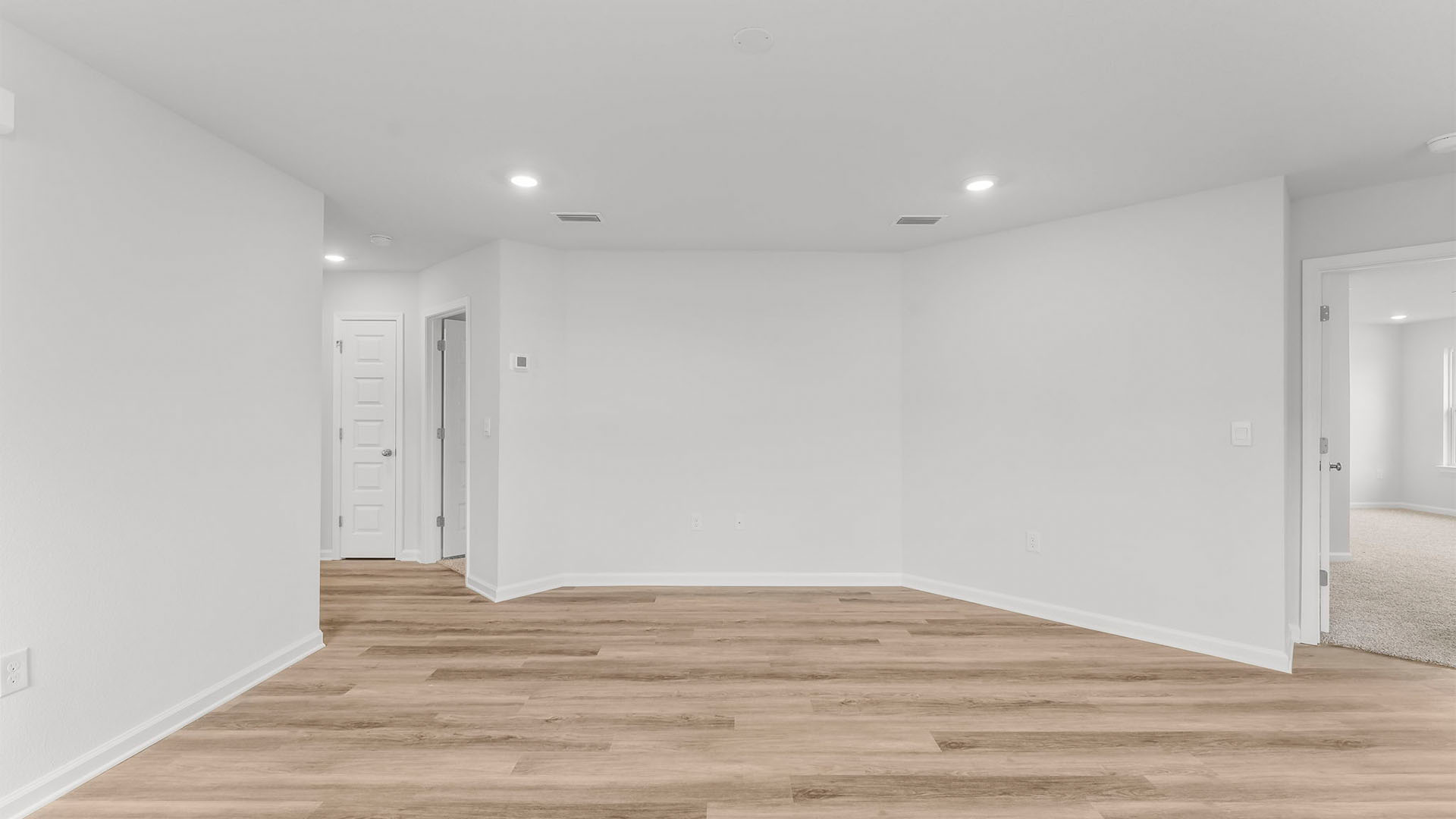 Living room with EVP flooring and hallway and bedroom entrances.
