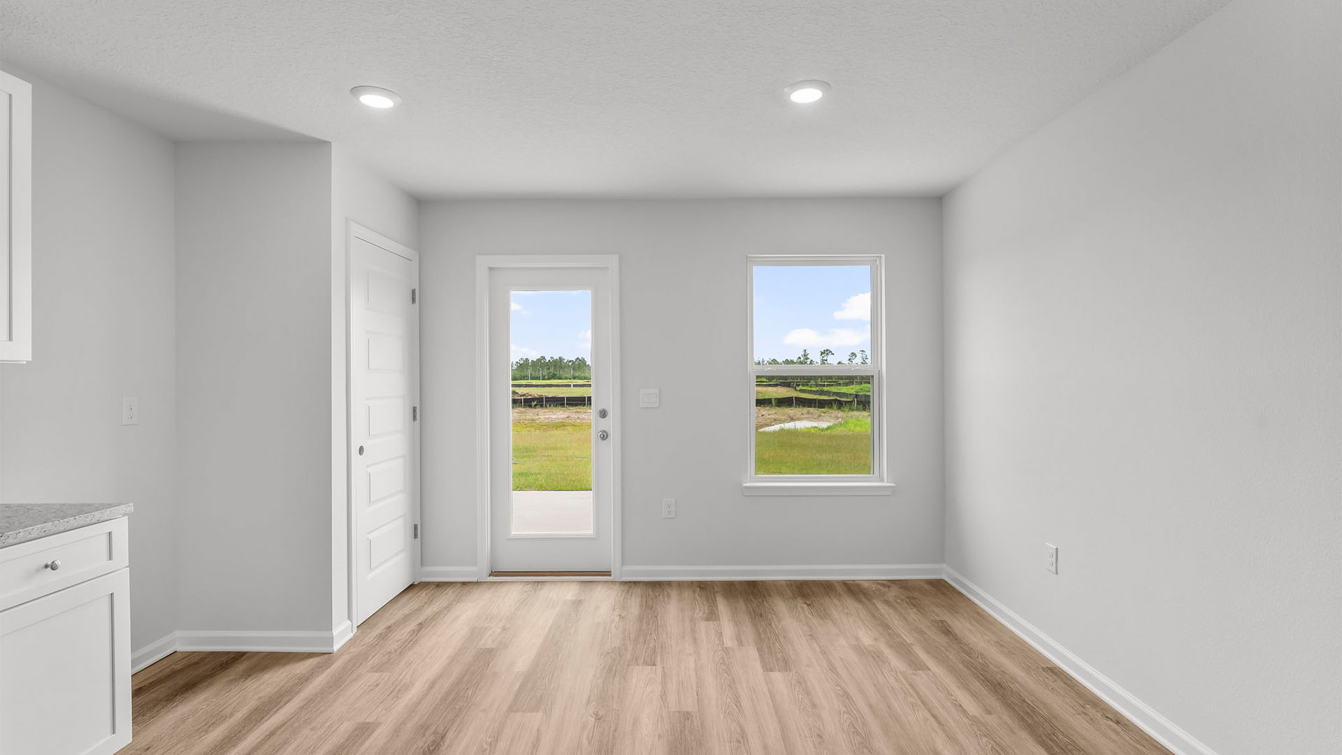 Kitchen with EVP flooring and granite countertops and back door.