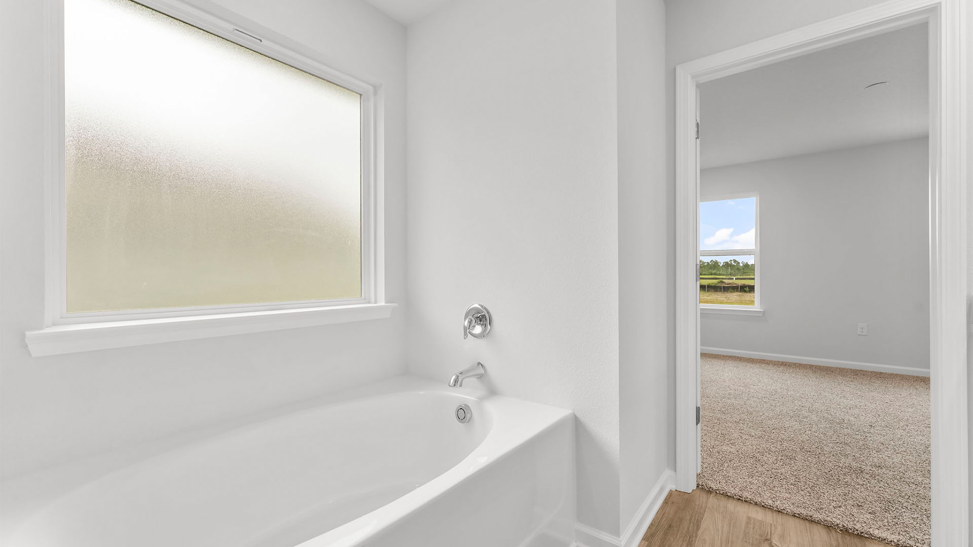 Primary bathroom tub and frosted mirror.