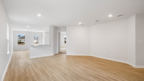 Living room with EVP flooring and open kitchen.