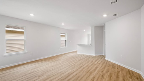 Living room with EVP flooring and two windows.