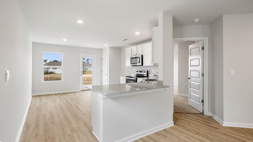 Kitchen with granite countertops and dining area.