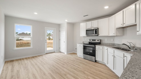 Kitchen with granite countertops and stainless-steel appliances and back door.