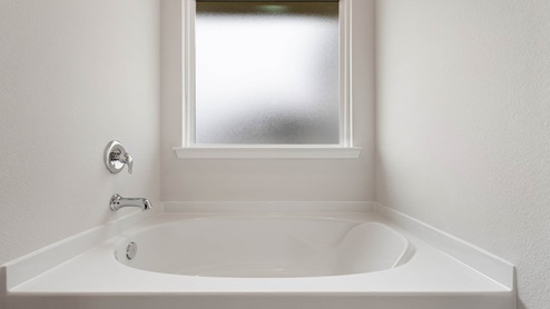 Primary bathroom tub and frosted mirror.