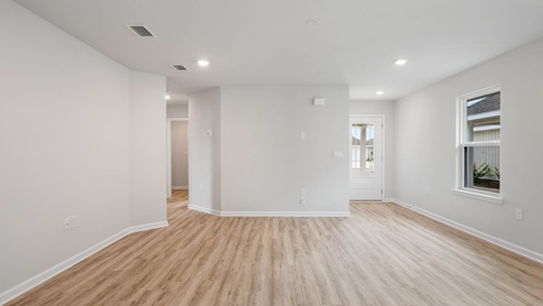 Living room with EVP flooring and prairie style front door and hallway.