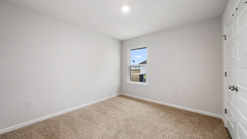 Bedroom with closet and carpet floor and window.