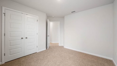 Bedroom with closet and carpet floors.