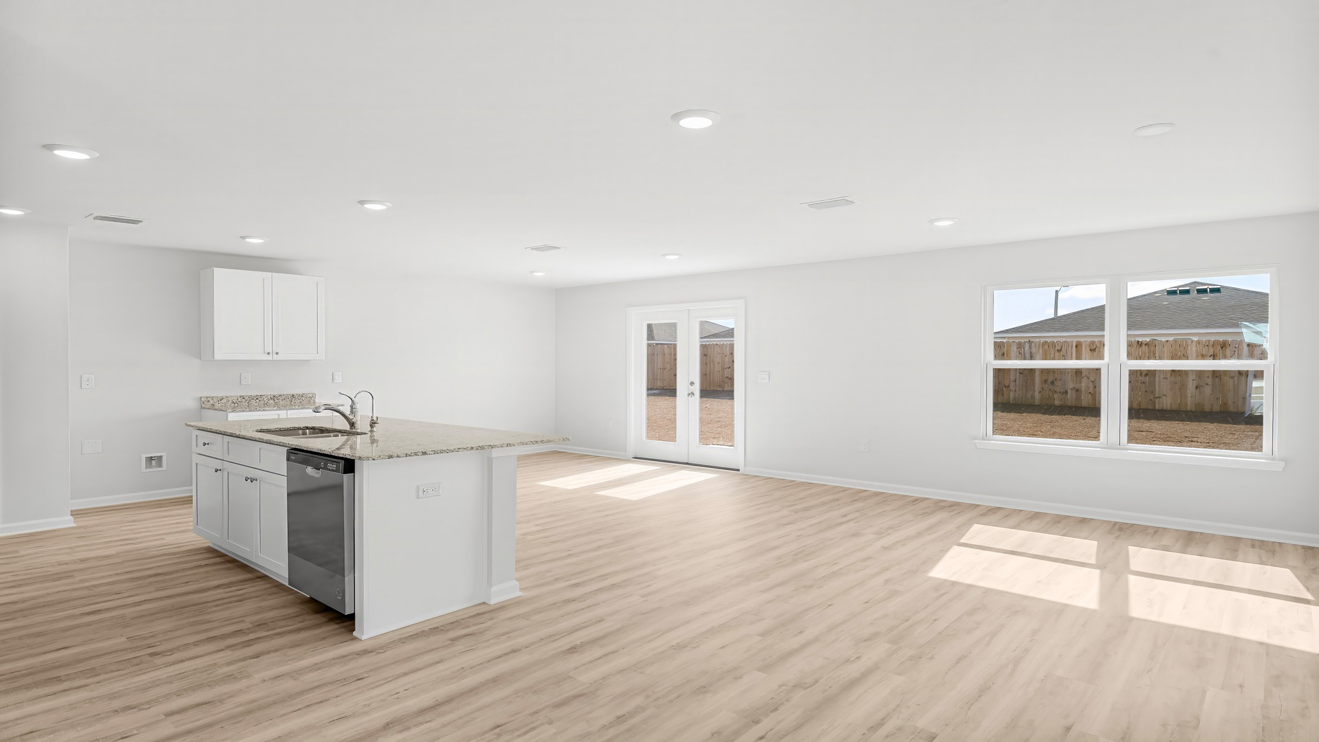 Open living room with EVP flooring and kitchen and dining area.