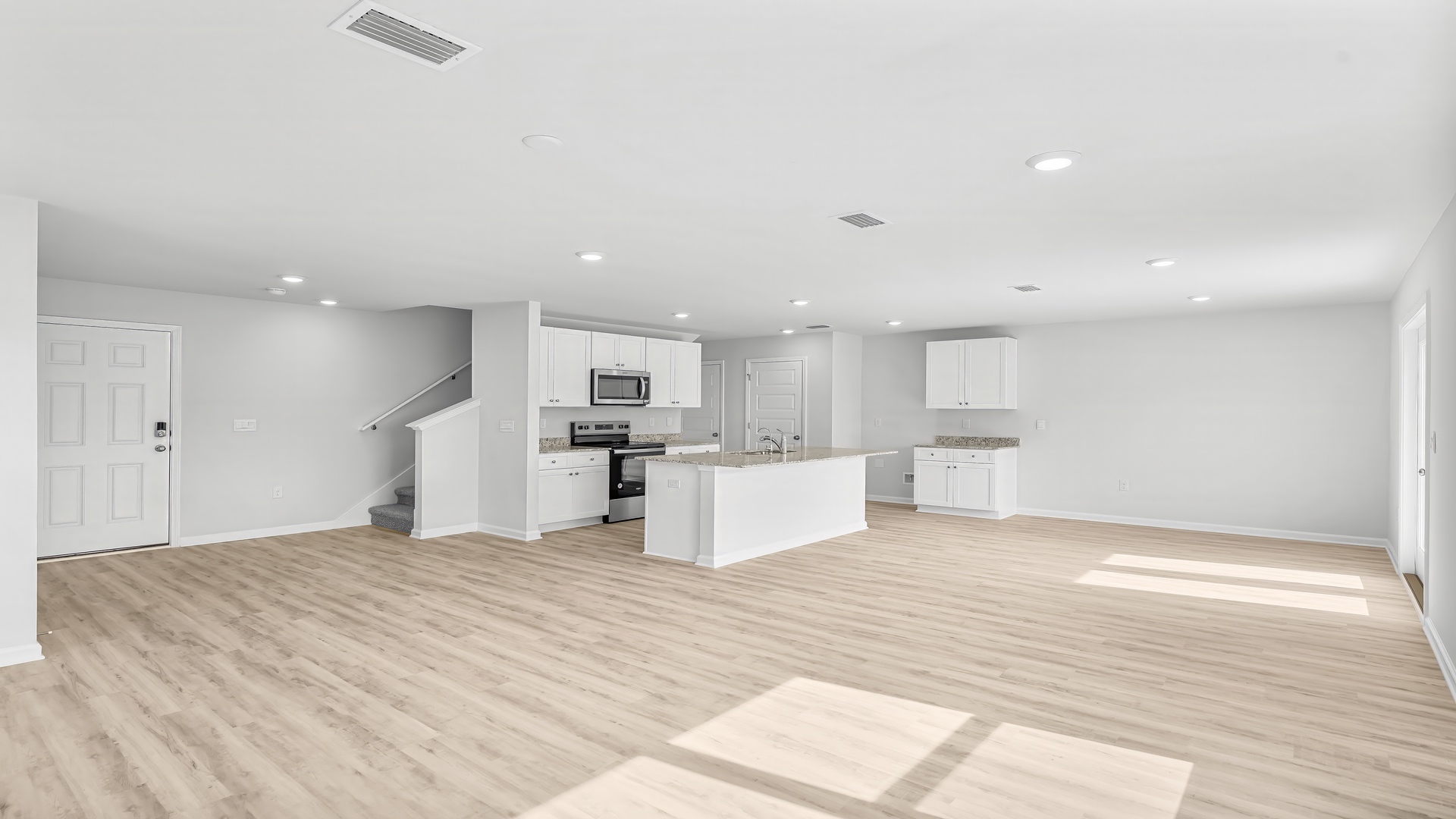 Open living room with EVP flooring and kitchen and dining area.