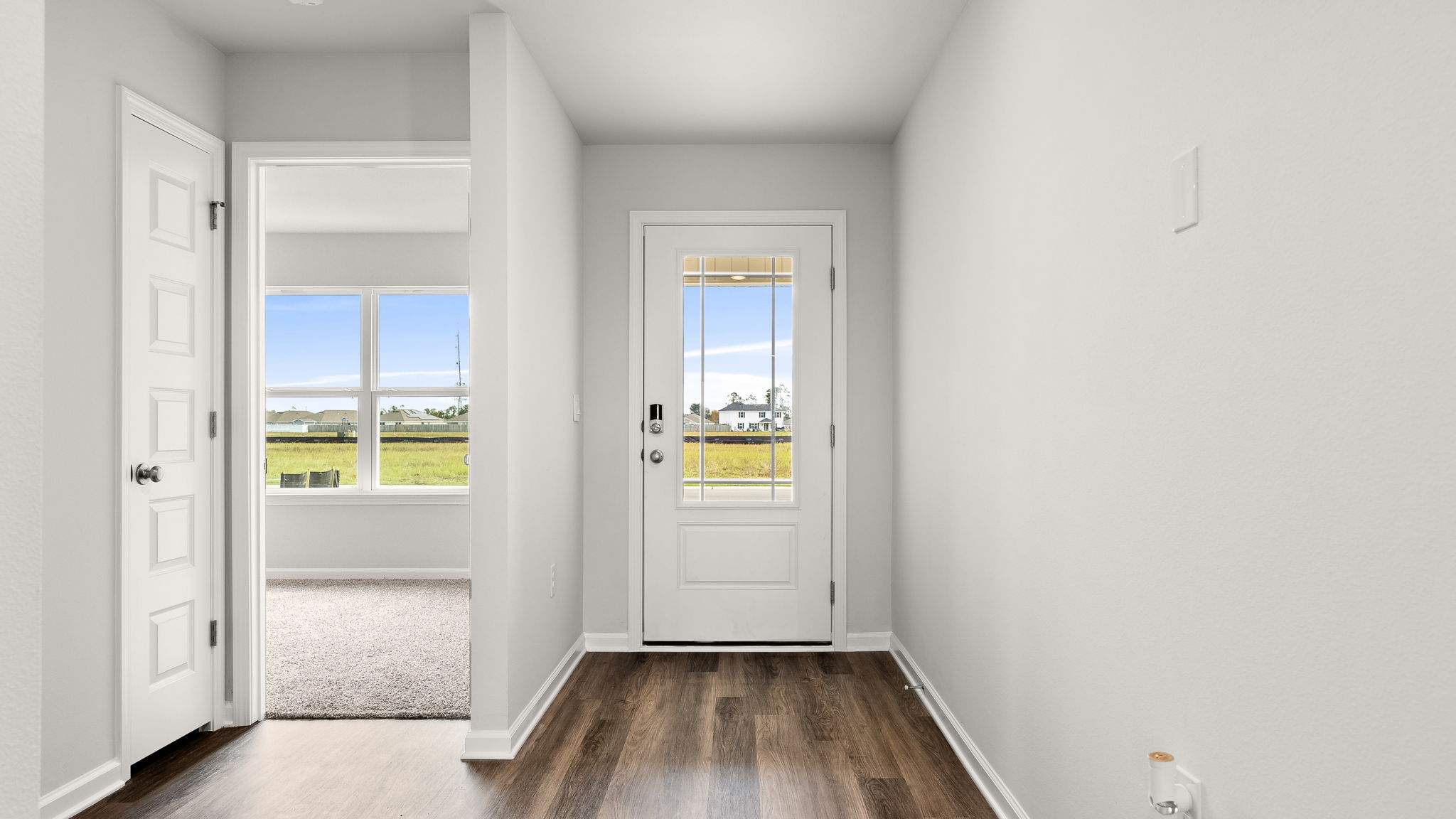 Front entrance hallway with EVP flooring next to garage and bedrooms.