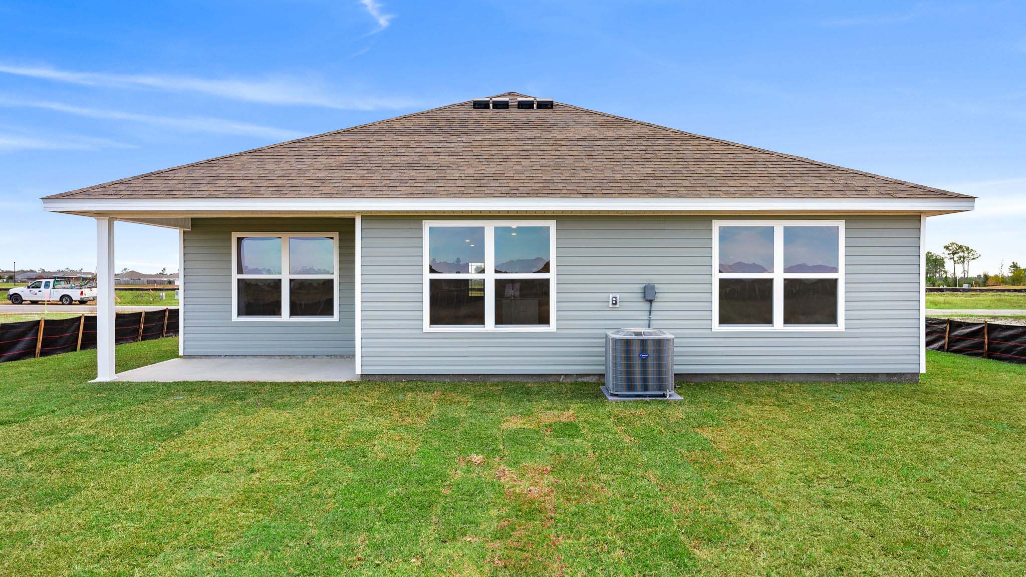 Aria plan rear of home with vinyl siding and covered patio.