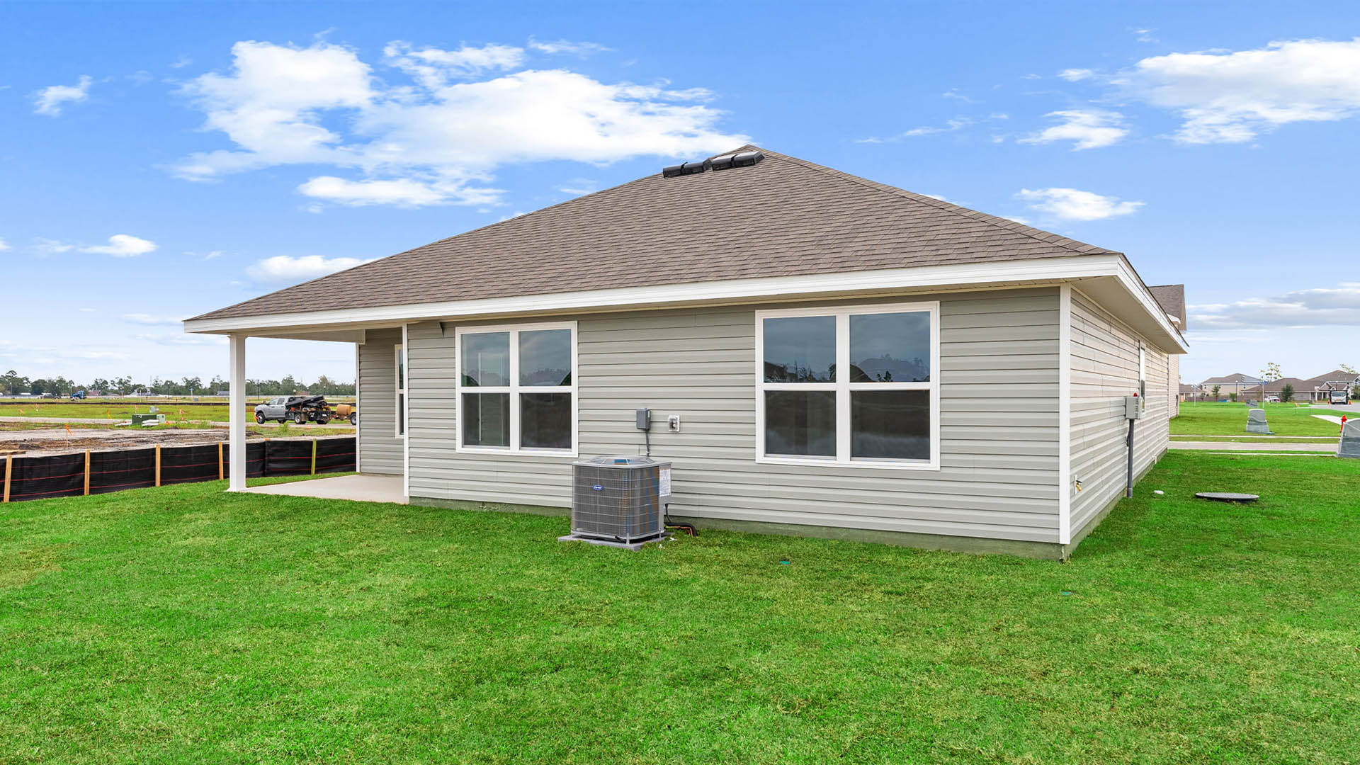 Aria plan at rear of home with vinyl siding and covered patio.