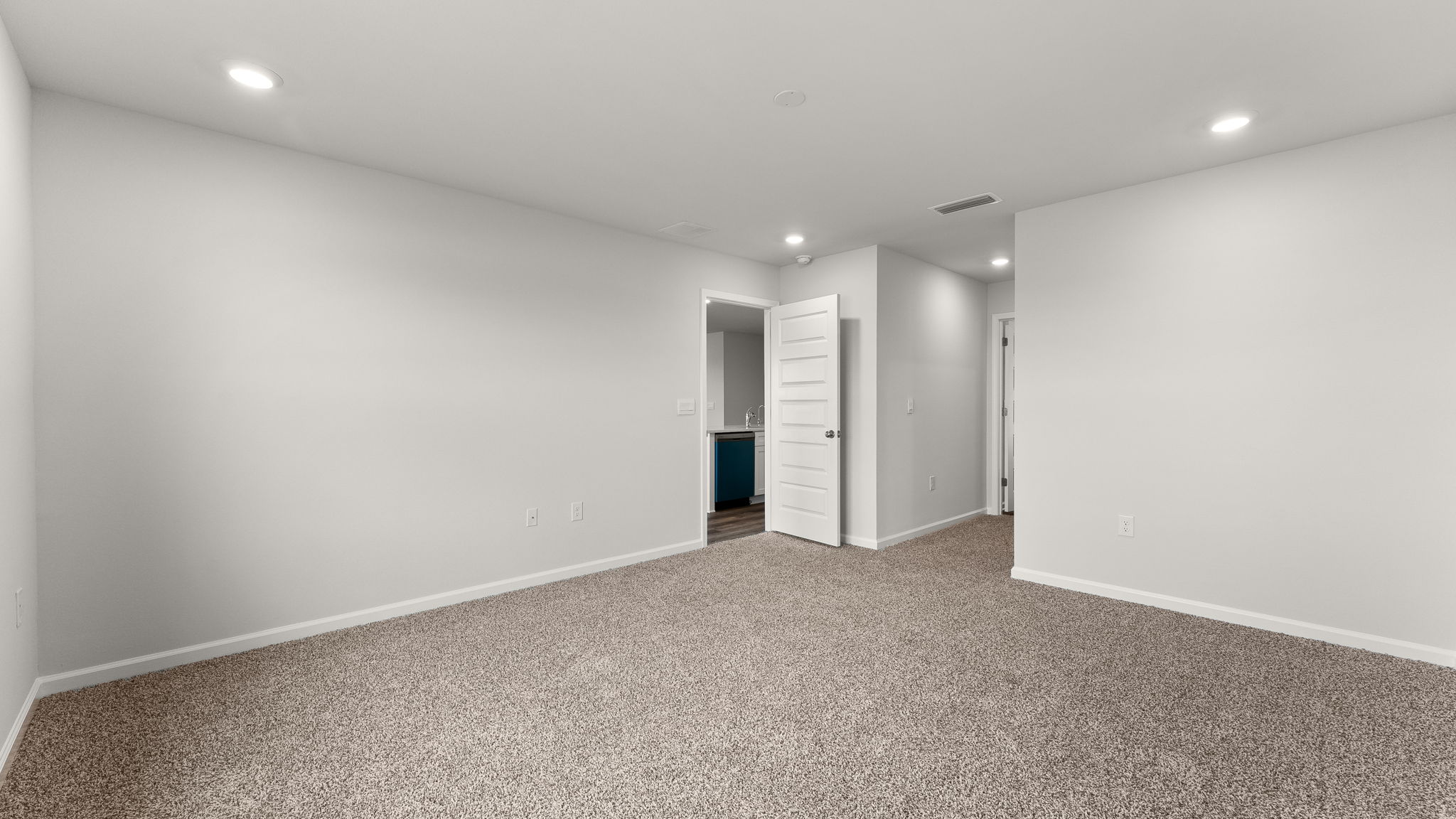 Primary bedroom with carpet floors and bathroom entrance.