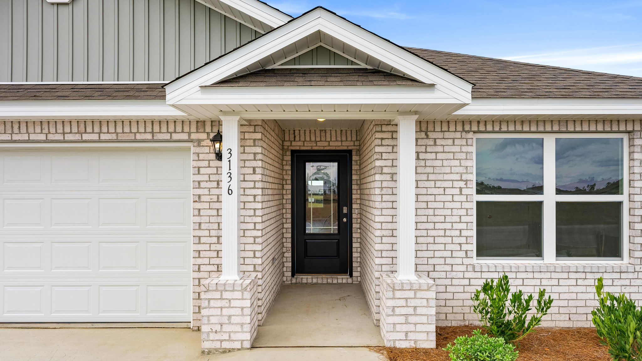 Covered front entrance with prairie style front door.