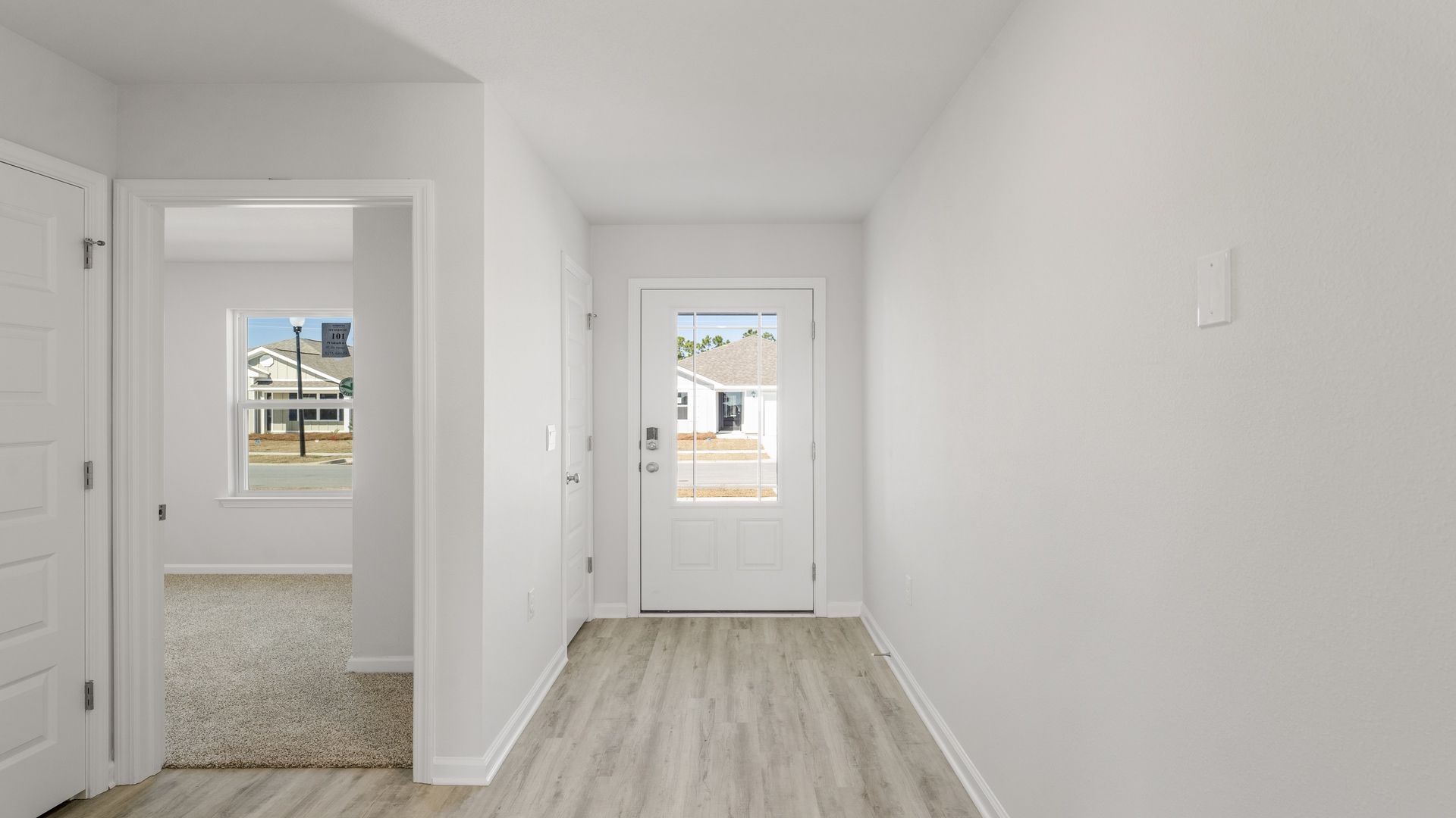 Front entrance next to bedroom with front door and EVP flooring.