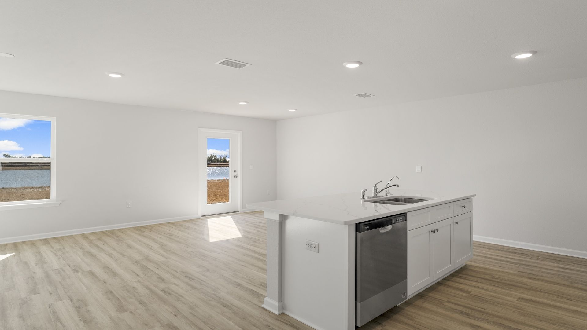 Kitchen island with quartz countertops and stainless-steel appliances.