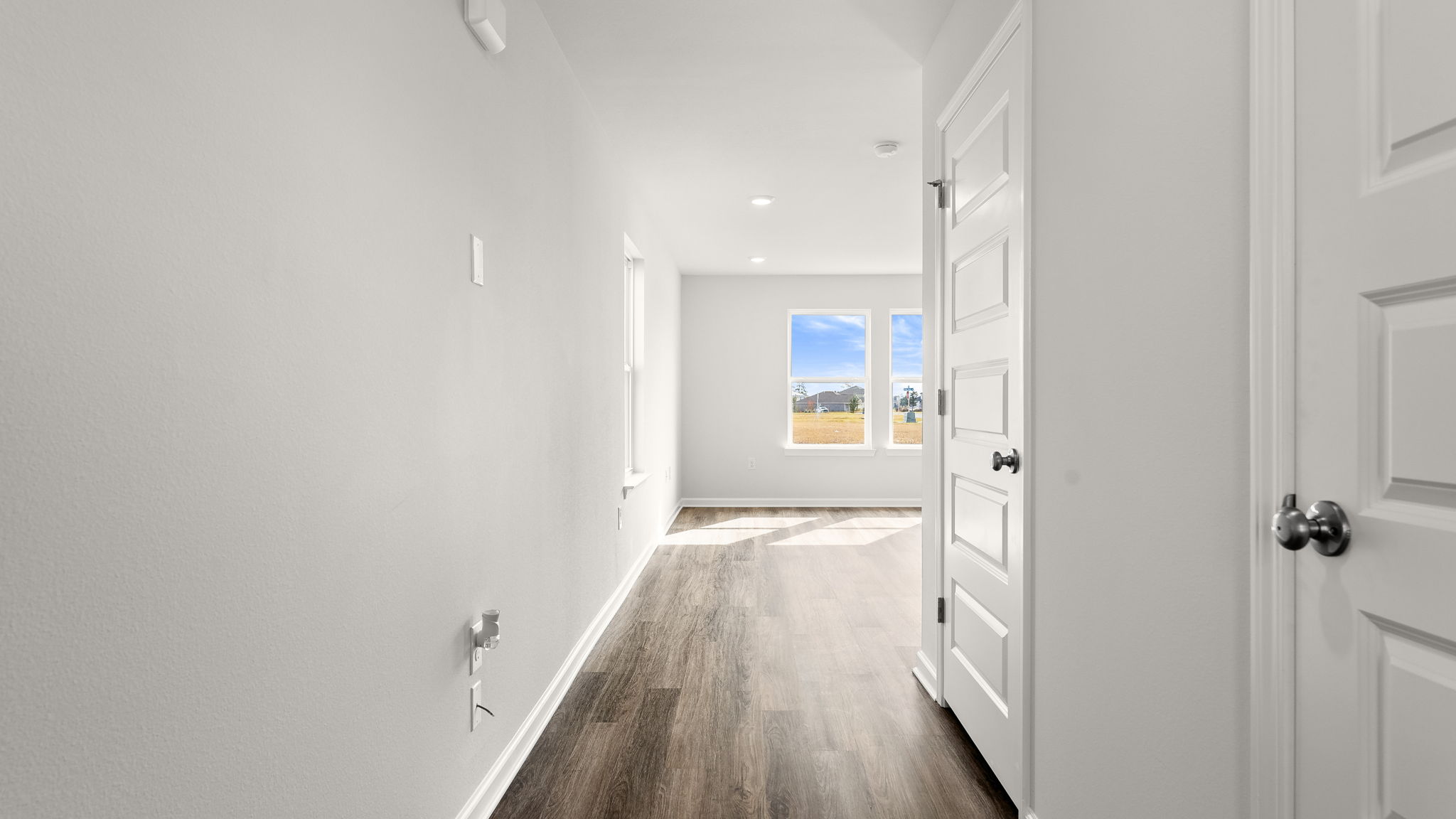Front entrance hallway with EVP flooring next to bathroom and stairs.