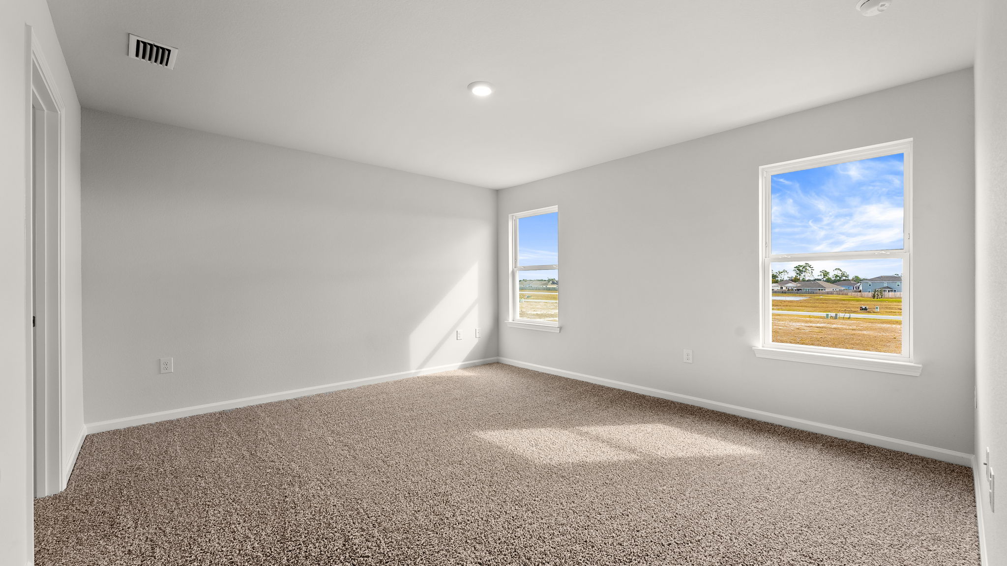 Primary bedroom with carpet flooring and windows.Primary bedroom with carpet flooring and windows.