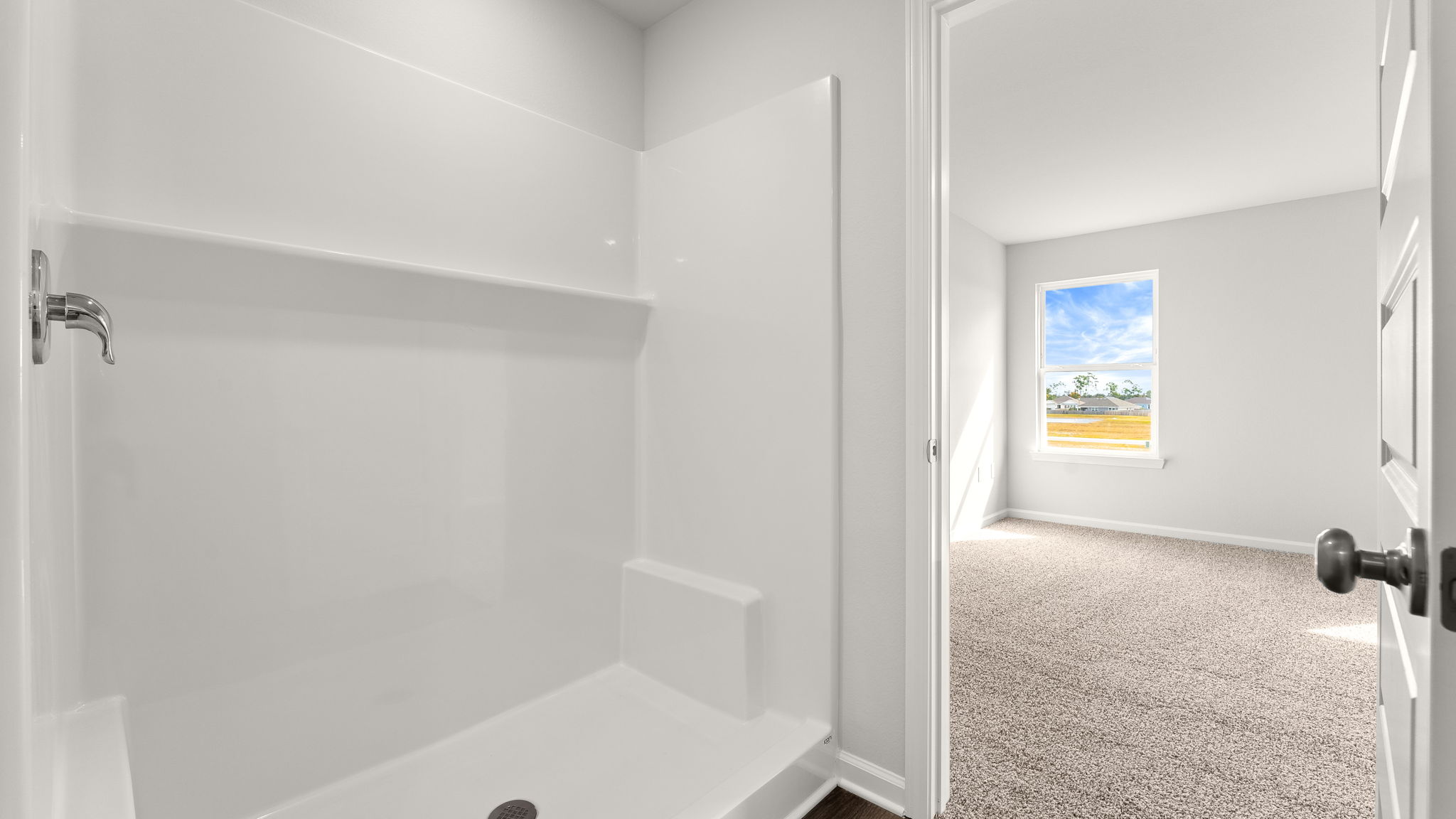 Primary bathroom shower and doorway.