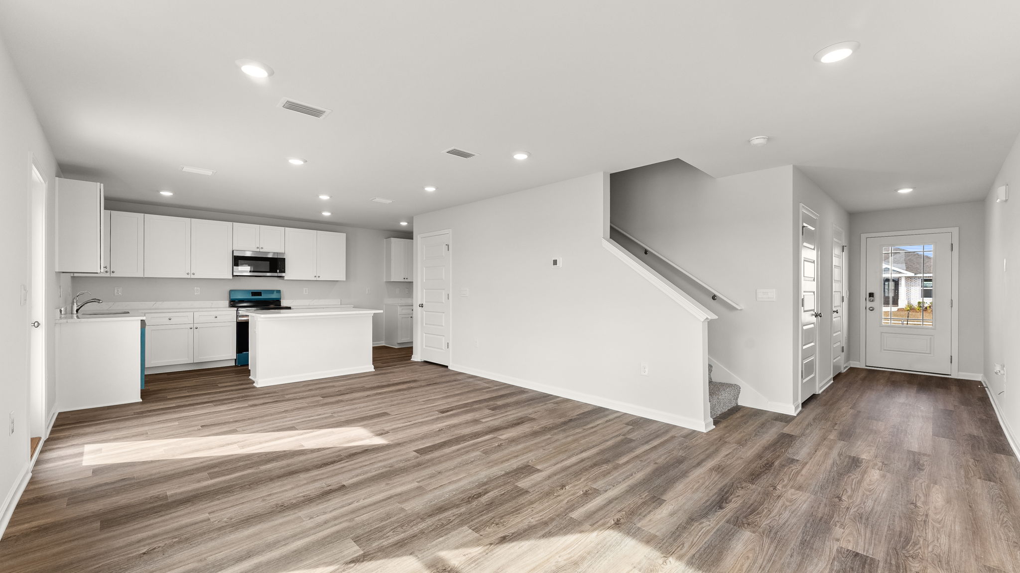 Living room and kitchen and front hallway view.