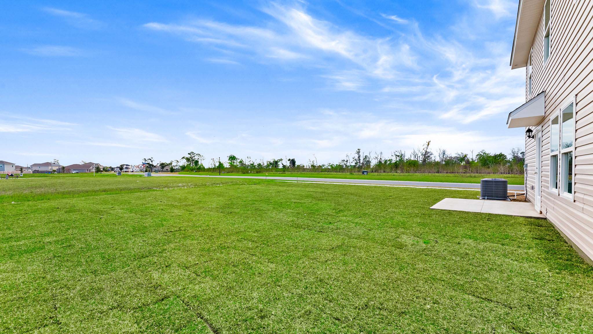 Back yard view with concrete patio and covered awning.