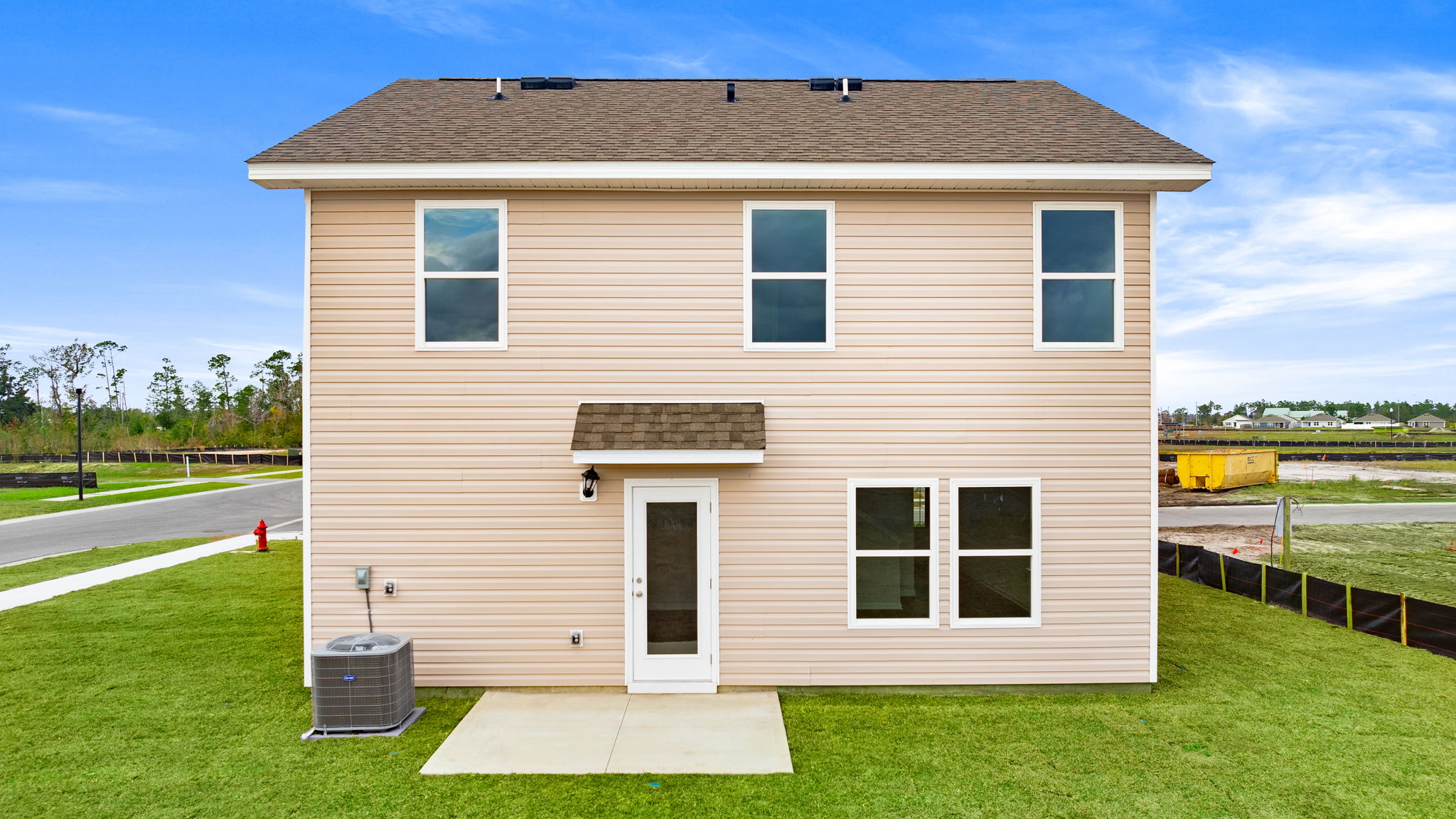 Taylor plan at rear of home with vinyl siding and covered patio.