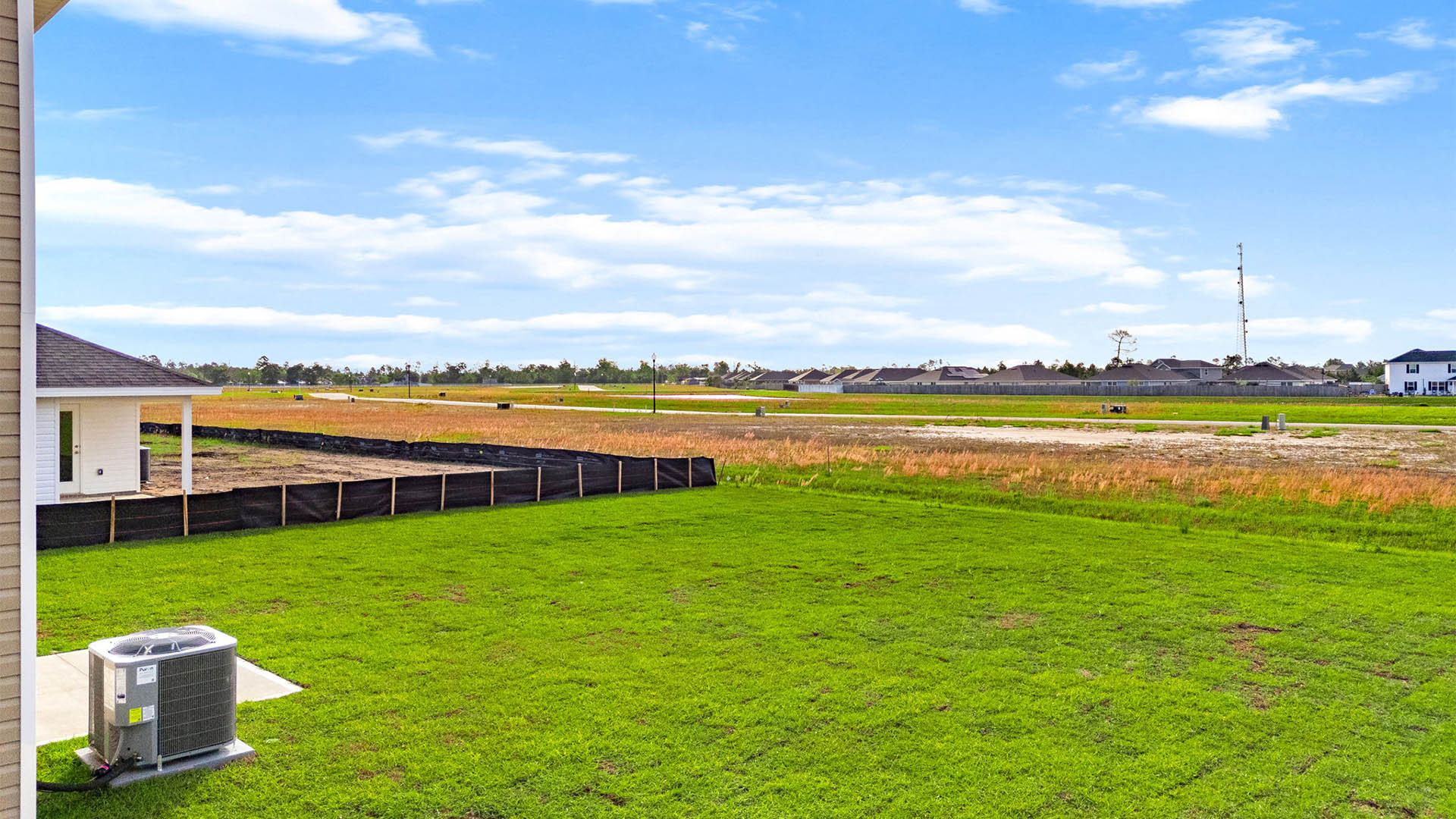 Back yard view with concrete patio and covered awning.