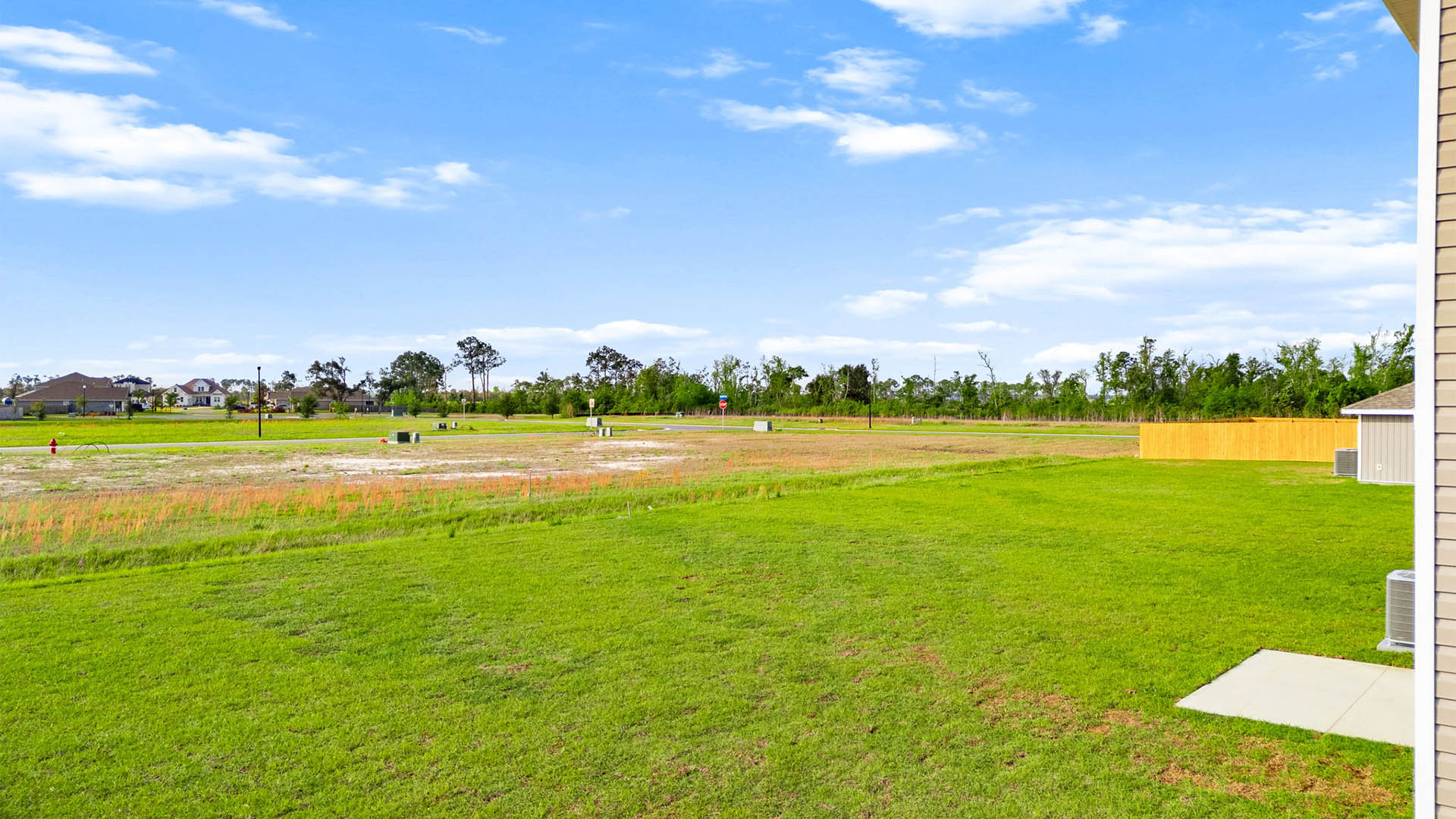 Back yard view with concrete patio and covered awning.