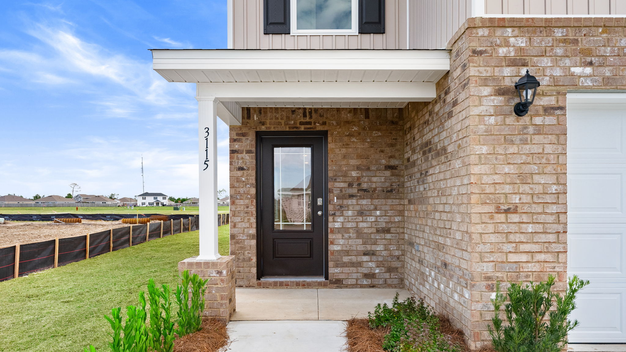Covered front entrance with prairie style front door.