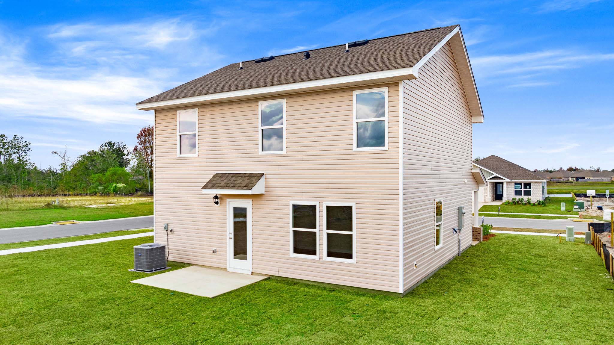 Taylor plan at rear of home with vinyl siding and covered patio.