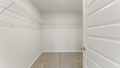 Master bathroom walk in closet with ventilated shelving.