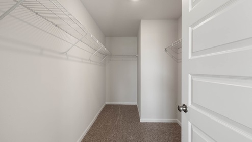 Walk in closet with ventilated shelving.