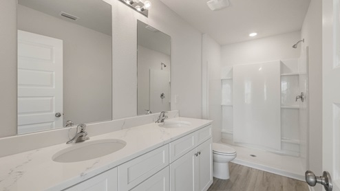 Master bathroom with quartz countertops and double vanity and shower.