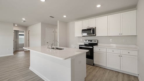 Kitchen and with island and quartz countertops and stainless-steel appliances.