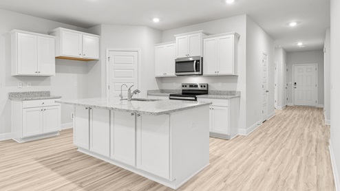 Kitchen with EVP flooring and white cabinets and granite countertops and stainless-steel appliances.