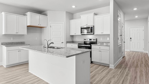 Kitchen with EVP flooring and white cabinets and granite countertops and stainless-steel appliances.