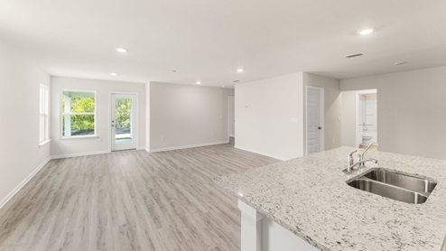 Open living room and kitchen with island and back door.