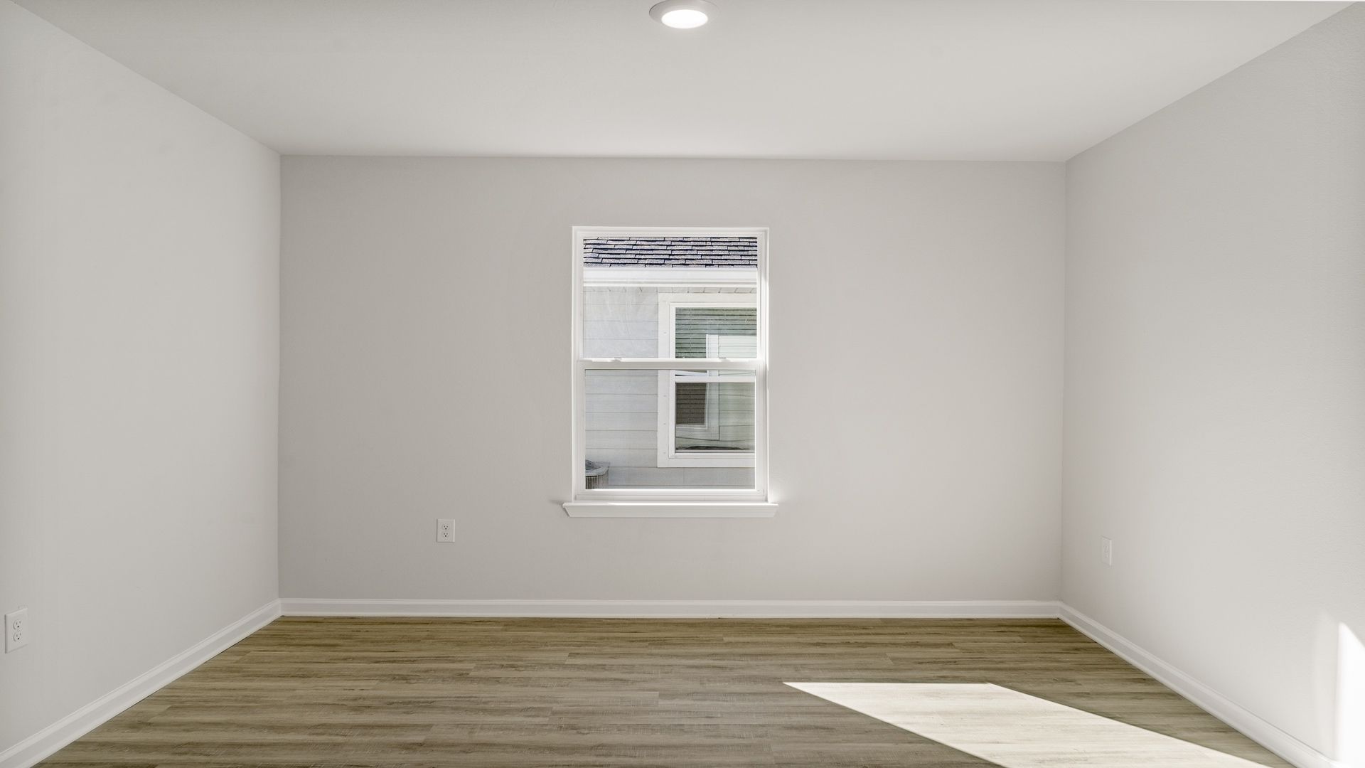 Bedroom with EVP flooring and window.