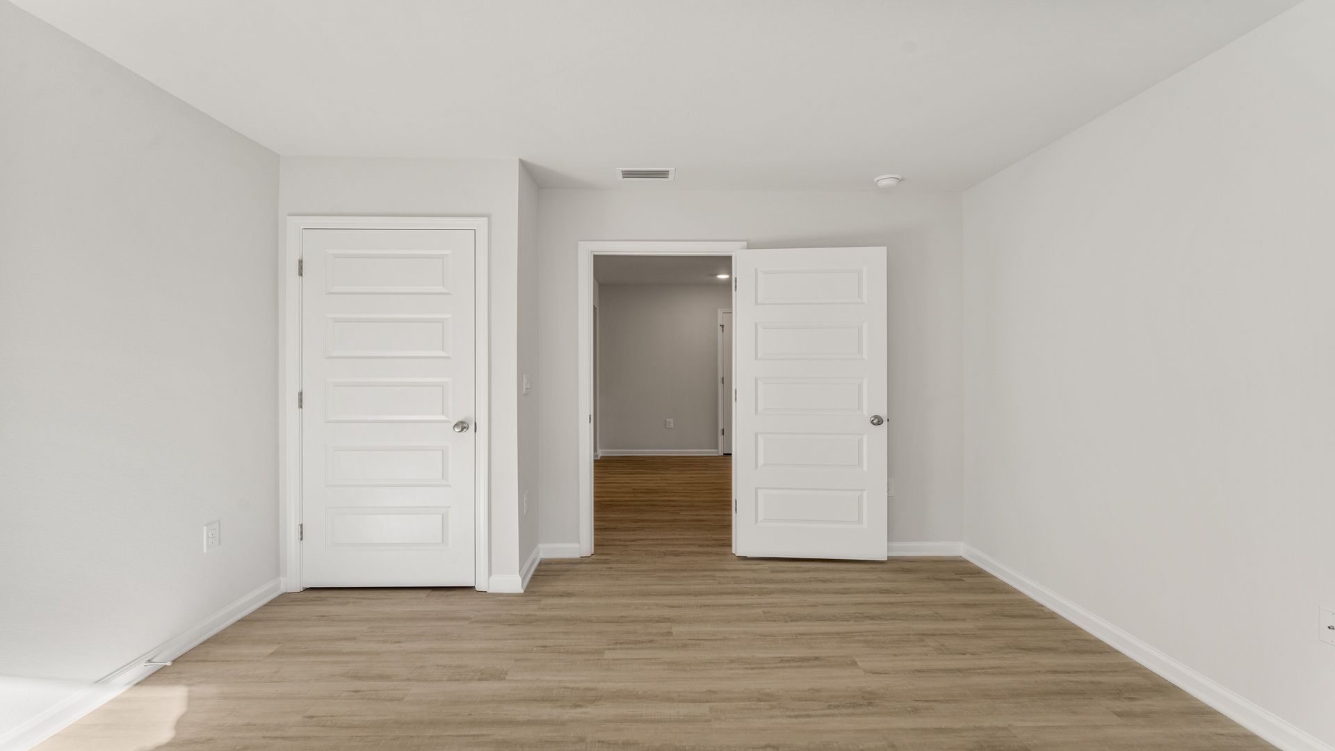 Bedroom with EVP flooring and closet.